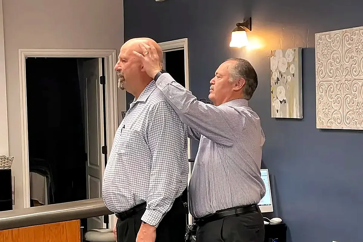 chiropractor performing standing cervical neck adjustment on patient california oaks chiropractic image 1